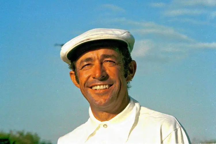Man wearing a white cap and shirt against a blue sky